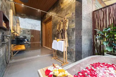a bathroom with a tub and a table with flowers at Villa Bolon in Kuta