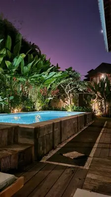 a swimming pool in front of a house at night at 2 Minutes Walk to the Beach 3BR Retreat Villa in Canggu