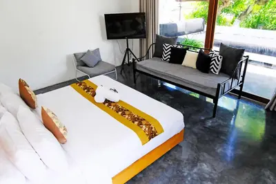 a living room with a large white bed and a couch at Modern & Central 3 Bedroom plus cinema in Seminyak