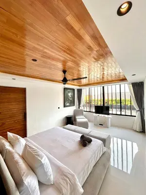 a bedroom with a large bed and wooden ceilings at Villa Kawis Seminyak in Seminyak