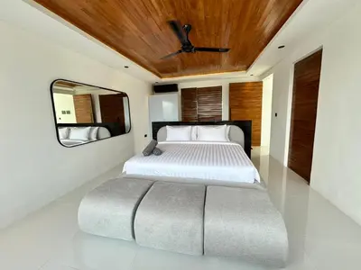a bedroom with a large bed and a mirror at Villa Kawis Seminyak in Seminyak
