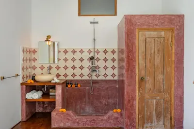 a bathroom with a shower and a wooden door at Villa N'Zo By DreamAwayBali in Seminyak