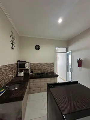 a kitchen with a sink and a microwave at 5 bedroom villa in kuta with 2 swimingpool in Kuta