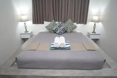 a bedroom with a bed with towels and two lamps at 5 bedroom villa in kuta with 2 swimingpool in Kuta