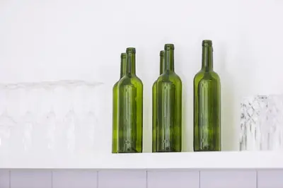 three green glass bottles sitting on a shelf at Ti - 1BR pool villa in the heart of Seminyak in Seminyak