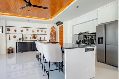 a kitchen with a large island with bar stools at Villa Kamawis Seminyak in Seminyak