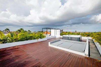 a deck with a kitchen and a grill on a roof at Villa Kamawis Seminyak in Seminyak