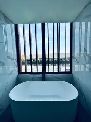 a bath tub in a room with a large window at Villa Kamawis Seminyak in Seminyak