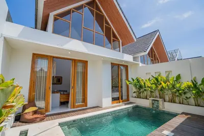 a house with a swimming pool in front of it at Sunrise Oasis - 2BR Villa in Kerobokan in Kerobokan