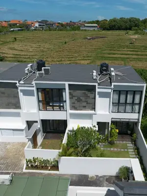 a white house with a view of a field at Sunrise Oasis - 2BR Villa in Kerobokan in Kerobokan