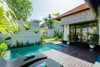 a backyard with a swimming pool and a house at Dion Villas Berawa only 5 Minutes by scooter to Finns beach club in Canggu
