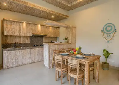 a kitchen with a wooden table and some chairs at Dion Villas Berawa only 5 Minutes by scooter to Finns beach club in Canggu