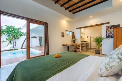 a bedroom with a large bed and a swimming pool at Villa Wuizy By DreamAwayBali in Seminyak