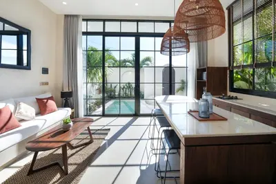 a kitchen and living room with a couch and a table at Villa Benteke Umalas in Kerobokan