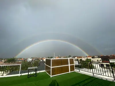 a rainbow in the sky over a balcony at Ayoolasudi in Kerobokan