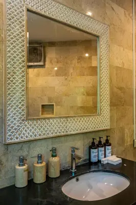 a bathroom sink with a mirror and four bottles of soap at 2BR Villa walking distance to Finns & Atlas in Canggu