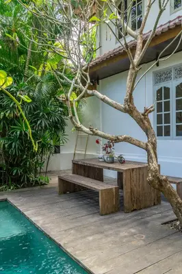 a wooden deck with a table next to a house at 2BR Villa in Umalas next to Seminyak & Canggu in Kerobokan