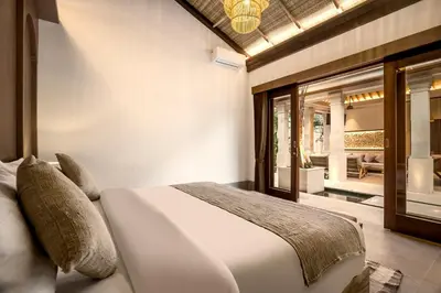 a bedroom with a white bed and a balcony at Villa Advaya by Maheswara in Seminyak