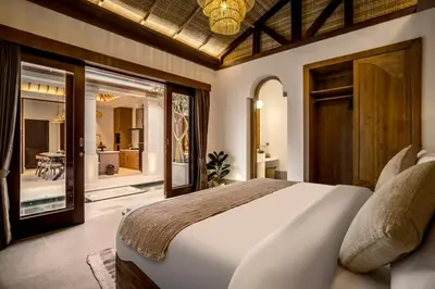 a bedroom with a large bed and a balcony at Villa Advaya by Maheswara in Seminyak