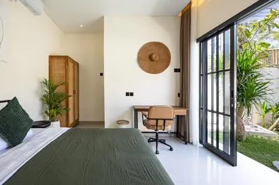 a bedroom with a bed and a desk and a window at Pool Garden Private 2BR Villa - 10 min to Finns Beach Club in Canggu