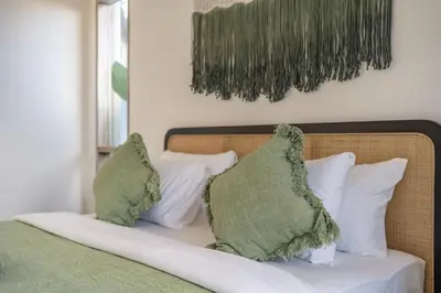 a bed with green and white pillows on it at La Palma - Spacious 2BR Villa with Large Pool in Canggu in Canggu