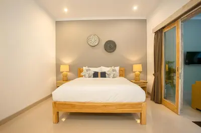 a bedroom with a bed and a clock on the wall at Villa D Canggu in Canggu