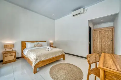 a bedroom with a bed and a table and chairs at Villa D Canggu in Canggu