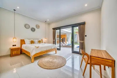 a bedroom with a bed and a table at Villa D Canggu in Canggu