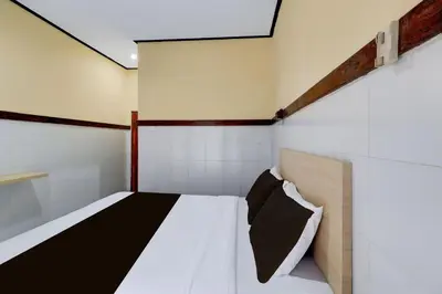 a bedroom with a bed in a room at Townhouse Oak Legian Near Kuta Beach Formerly Sayang Maha Merta in Legian