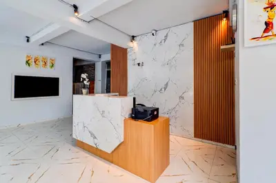 a lobby with a counter and a tv on a wall at Townhouse Oak Legian Near Kuta Beach Formerly Sayang Maha Merta in Legian