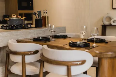 a wooden table with chairs and wine glasses on it at CAVO Villa in Seminyak
