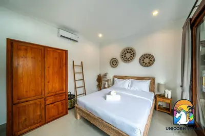 a bedroom with a bed and a wooden door at A&R4 Villa - by Unicorn Villas Bali in Seminyak