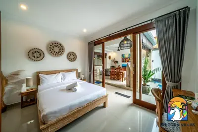 a bedroom with a bed and a large window at A&R4 Villa - by Unicorn Villas Bali in Seminyak