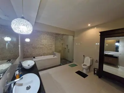 a bathroom with a sink and a tub and a toilet at Max Guest House in Seminyak