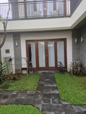 a front door of a house with a balcony at Max Guest House in Seminyak
