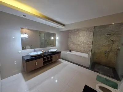 a large bathroom with two sinks and a shower at Max Guest House in Seminyak
