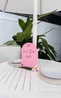 a pink sign sitting on top of a table at The Pink Door Villa in Legian