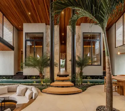 a living room with a couch and palm trees at House of Winds Complex - Luxury 6BR Tropical Retreat - 2x3BR Villas near Canggu in Kerobokan