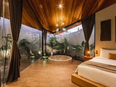 a bedroom with a tub in a room with plants at House of Winds Complex - Luxury 6BR Tropical Retreat - 2x3BR Villas near Canggu in Kerobokan