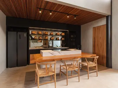 a kitchen with a wooden table and chairs at House of Winds Complex - Luxury 6BR Tropical Retreat - 2x3BR Villas near Canggu in Kerobokan