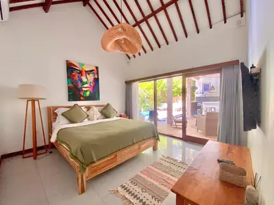 a bedroom with a bed and a table at Villa Pastis Umalas #2, near Canggu in Canggu