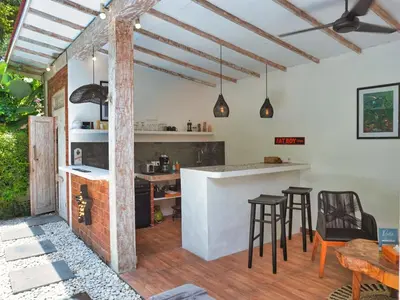 a kitchen and dining room with a counter and stools at Villa Pastis Umalas #2, near Canggu in Canggu
