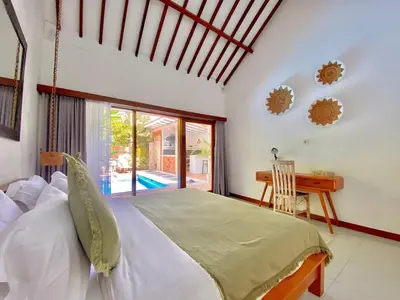 a bedroom with a bed and a desk and a window at Villa Pastis Umalas #2, near Canggu in Canggu