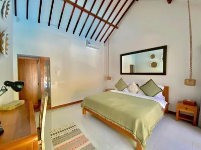 a bedroom with a bed and a mirror on the wall at Villa Pastis Umalas #2, near Canggu in Canggu
