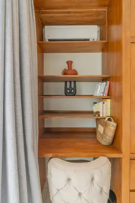 a book shelf with a curtain next to a desk at Villa Agua Dream Canggu hideaway in Canggu