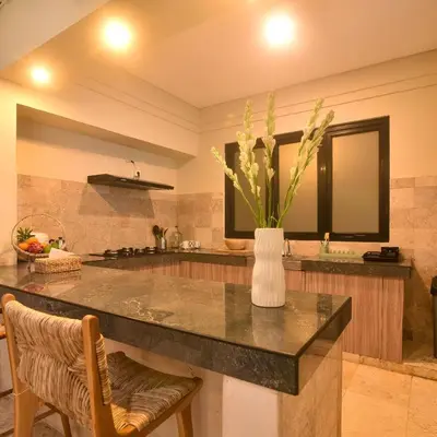 a kitchen with a counter with a vase with flowers on it at Villa EL Noya Umallas in Badung