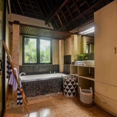 a bathroom with a bath tub and a window at Villa EL Noya Umallas in Badung