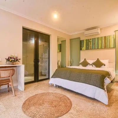 a bedroom with a large bed and a table at Villa EL Noya Umallas in Badung