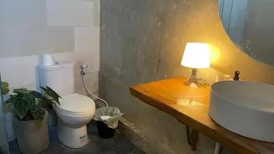 a bathroom with a sink and a toilet and a lamp at Spacious Family Home & Office Canggu, stay with cats in Canggu