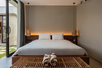 a bedroom with a large bed with a wooden headboard at Solencia Villa by Betterplace in Jimbaran